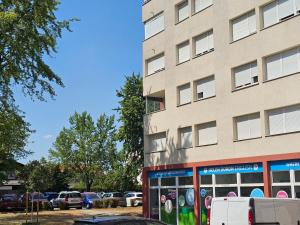 a building with cars parked in a parking lot at Apartman u Velikoj Gorici Željko in Velika Gorica