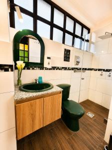 a bathroom with a green toilet and a sink at Hostal Riviera Sucre in Otavalo +87 photos