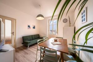 a living room with a table and a green couch at Villetta Allegra in Appiano sulla Strada del Vino