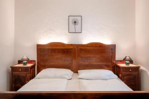 a bedroom with a wooden bed with two night stands at Villetta Allegra in Appiano sulla Strada del Vino