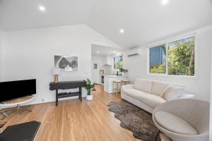 a living room with a couch and a piano at AquaLuna Beach House in Aireys Inlet