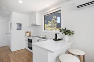 a white kitchen with a sink and a window at AquaLuna Beach House in Aireys Inlet