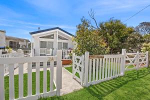 a white fence in front of a house at AquaLuna Beach House in Aireys Inlet +7 photos