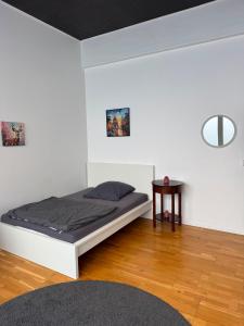 a white bedroom with a bed and a table at City Room 2 Stuttgart-Mitte in Stuttgart