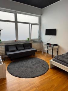 a living room with a couch and a television at City Room 2 Stuttgart-Mitte in Stuttgart