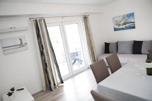 a living room with a table and a room with a couch at Apartments Gabrijel in Vodice