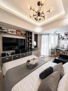 a bedroom with a large bed with a large television at Z Crib - Azure North in San Fernando