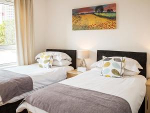 a bedroom with two beds and a painting on the wall at Oakdale at Centrium in Woking