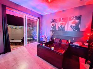 a room with a jacuzzi tub with red lighting at L'antre Parenthèse 46 in Souillac