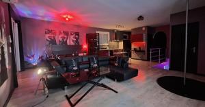 a living room with a black couch and a kitchen at L'antre Parenthèse 46 in Souillac