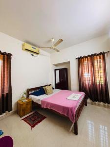 a bedroom with a large bed with a pink blanket at Dream Nest Beach House in Alleppey +37 photos