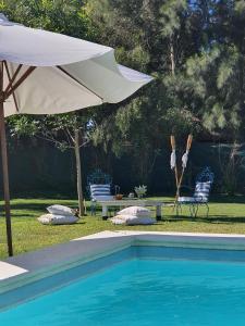 a pool with an umbrella and a table and chairs at La Constancia in Parana
