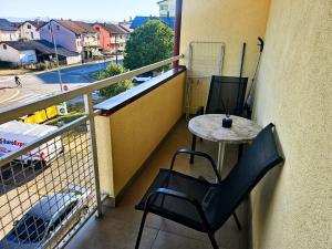 a balcony with a table and chairs and a street at Apartman Dona in Bosanska Gradiška