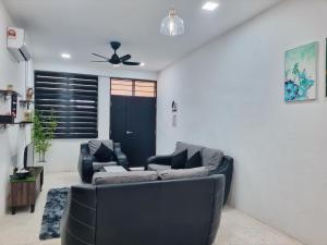 a living room with a couch and a ceiling fan at HomeStay with Serene Surrounding in Nibung Tebal