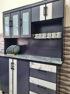 a kitchen with black and white cabinets and a counter at HomeStay with Serene Surrounding in Nibung Tebal