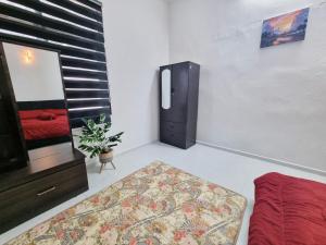 a room with a tv and a couch and a mirror at HomeStay with Serene Surrounding in Nibung Tebal