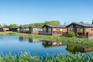 a row of modular homes next to a lake at Poppy in Leominster