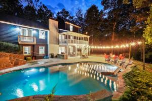 a swimming pool in front of a house at night at Georgia Lakeside Getaway with Private Pool in Flowery Branch