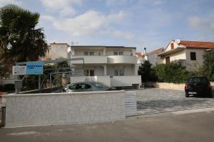 a car parked in a parking lot in front of a house at Apartments Gabrijel in Vodice