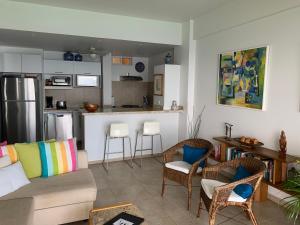 a living room with a couch and chairs and a kitchen at Playas Gemelas Puerto Vallarta in Puerto Vallarta