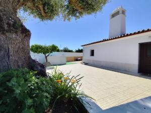 a view of the courtyard of a church with a tree at Monte do Ti'Mota in São Lourenço de Mamporcão