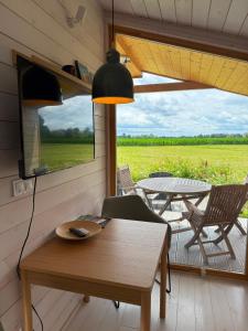 a living room with a table and a view of a patio at 102 Tiny House in erster Reihe mit Kamin & Blick ins Grüne in Bleckede +18 photos