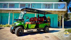 a green golf cart parked in front of a building at Family Tides in Holmes Beach
