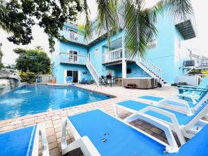 a swimming pool with chairs and a building at Family Tides in Holmes Beach