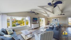 a living room with blue couches and windows at Family Tides in Holmes Beach