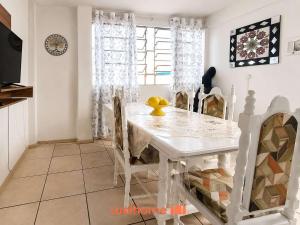 a dining room with a white table and chairs at Cobertura com Vista e Conforto no RS in Santo Ângelo