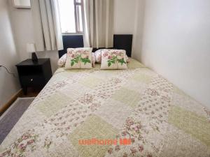 a bedroom with a bed with a quilt on it at Cobertura com Vista e Conforto no RS in Santo Ângelo +19 photos