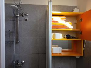 a bathroom with a shower and shelves with towels at Studio Celjeapp in Celje