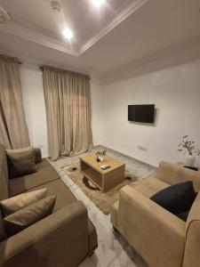 a living room with two couches and a tv at Al-ihsan Metro Hotel in Kaduna