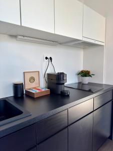 a kitchen with a black counter top with a appliance at Cozy Apartment with Castle view in Staré Mesto