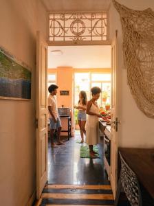 a group of people standing in a kitchen at Odara Hostel & Guesthouse in Salvador +64 photos