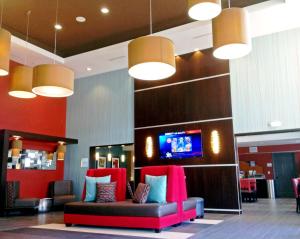 a lobby with a couch and a tv on a wall at Holiday Inn Express Bakersfield by IHG in Bakersfield