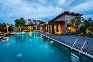 武里南Cresco Hotel Buriram的建筑物前的一个大型游泳池
