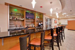 a bar with a row of chairs at a restaurant at Holiday Inn Hotel & Suites Gateway by IHG in Williamsburg