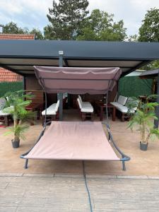a canopy on a patio with chairs and tables at A-Frame Wellness Villa with Private Pool, Sauna & Jacuzzi near Belgrade in Koraćica