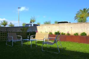 a group of chairs sitting in the grass at Apartamentos turísticos El Pinar in Mogro