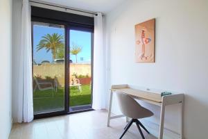 a white room with a desk and a sliding glass door at Apartamentos turísticos El Pinar in Mogro +120 photos
