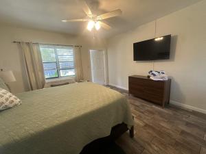 a bedroom with a bed and a flat screen tv at Studio in Pompano Beach two blocks from the Ocean in Pompano Beach