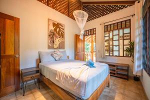 a bedroom with a bed and a window at Osos Caribeños - with Garden - 400m from the Beach in Punta Uva