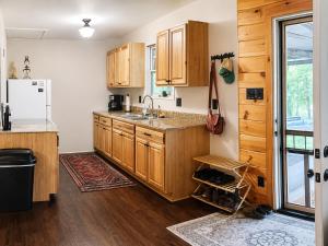 a kitchen with wooden cabinets and a refrigerator at Cameron's Cottage at The Lake in Tallassee