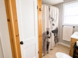 a bathroom with a shower curtain and a toilet at Cameron's Cottage at The Lake in Tallassee +25 photos