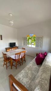 a living room with a table and a couch at Residencial Sombreiro - a 50 m da praia in Florianópolis
