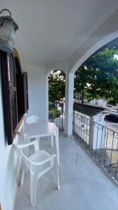 a white table and chairs on a balcony at Residencial Sombreiro - a 50 m da praia in Florianópolis