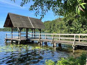 a wooden dock with a gazebo on the water at Ferienwohnung Nordic Stay Bäk in Bäk