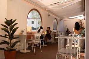 a restaurant with white chairs and people sitting at tables at Kontiki Miraflores in Lima