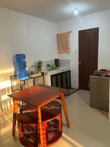 a kitchen with a wooden table and two chairs at Vin's Transient WiFi Netflix City Hall-DRMC-EPark in Tagum